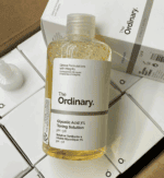 Close-up of The Ordinary Glycolic Acid 7% Toning Solution bottle placed on top of stacked product boxes