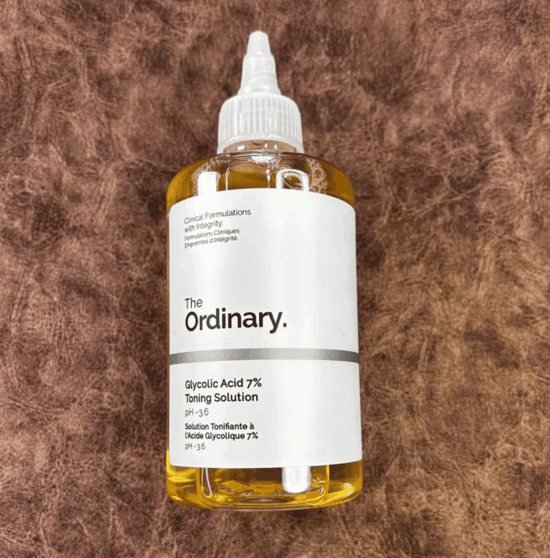 The Ordinary Glycolic Acid 7% Toning Solution bottle on a brown textured surface
