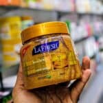 La Fresh Gold Scrub jar 500ml with gold cap, held in hand in a store aisle