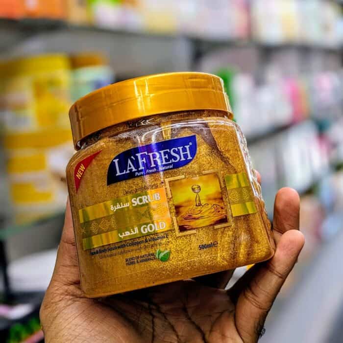 La Fresh Gold Scrub jar 500ml with gold cap, held in hand in a store aisle