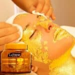 Facial treatment with gold mask applied to a woman's face, using La Fresh Gold Scrub jar 500ml