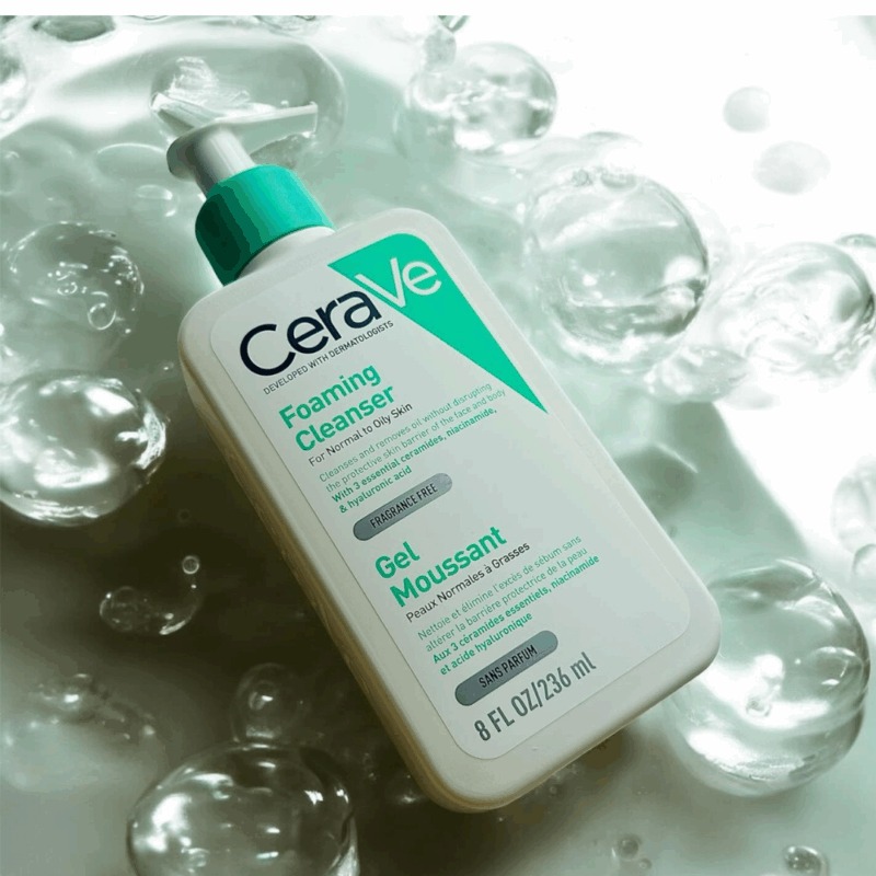 CeraVe Foaming Cleanser bottle placed on a surface with water bubbles, 236ml pump packaging for normal to oily skin, enriched with ceramides, niacinamide, and hyaluronic acid.