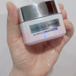 L’Oréal Glycolic-Bright Glowing Night Cream in a square white jar with a shiny silver lid, placed against a plain background.