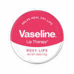 Vaseline Lip Therapy Rosy Lips balm in a round 17g tin with a pink top and white bottom background, featuring the text “Helps Heal Dry Lips” and “Rosy Lips.”