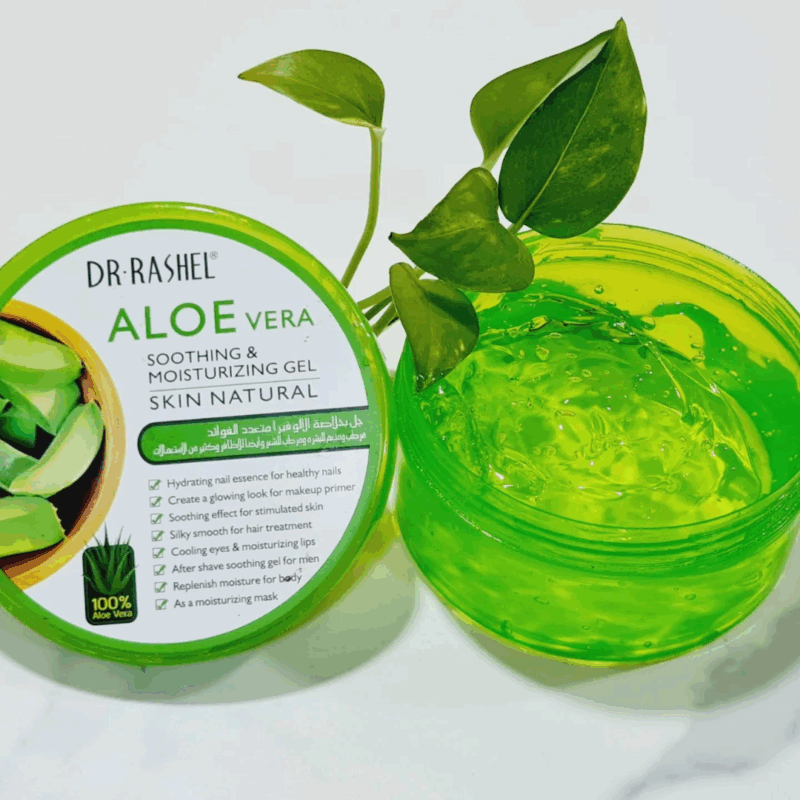 Open jar of Dr Rashel Aloe Vera Soothing & Moisturizing Gel showing clear gel texture, placed beside its green lid featuring aloe leaf graphics, with fresh green leaves for a natural skincare look on a white background.