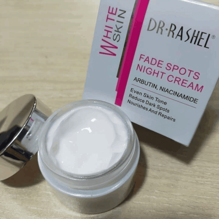 Open jar of Dr Rashel White Skin Fade Spots Night Cream with glossy silver lid, showing the creamy texture inside, placed beside its box highlighting Arbutin and Niacinamide for even skin tone and dark spot reduction.
