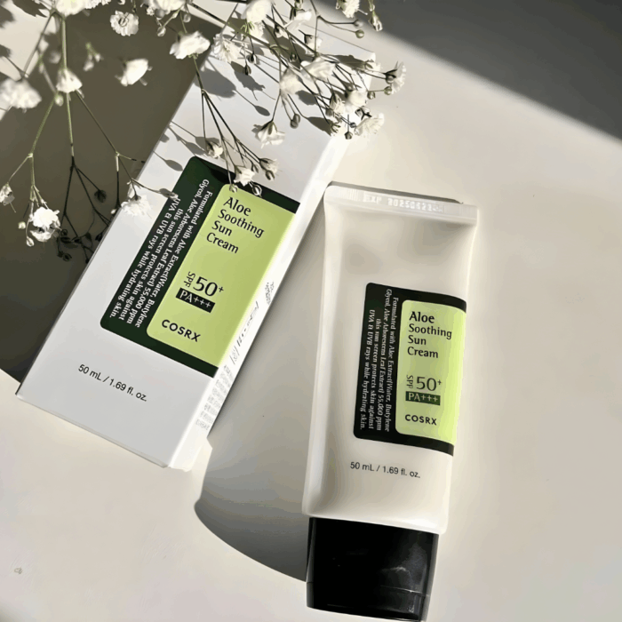 COSRX Aloe Soothing Sun Cream SPF 50+ PA+++ with box packaging, displayed with flowers.