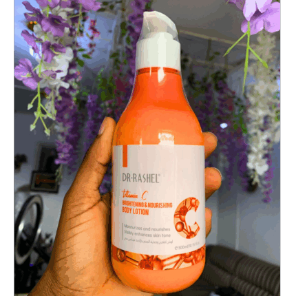 Hand holding Dr Rashel Vitamin C Brightening & Nourishing Body Lotion 300ml bottle with floral background.