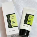 COSRX Aloe Soothing Sun Cream SPF 50+ PA+++ with box, placed on white fabric.