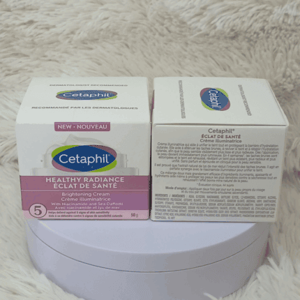 Two boxes of Cetaphil Healthy Radiance Brightening Cream 50g displayed side by side on a soft fabric surface, showing the front and back labels with niacinamide and Sea Daffodil formula details.