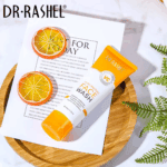 Dr Rashel Vitamin C Brightening Face Wash tube placed on a wooden tray with dried orange slices and decorative greenery.