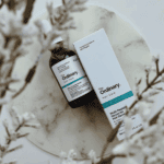 A bottle and box of The Ordinary Multi-Peptide Serum for Hair Density displayed on a marble surface. The serum promotes thicker, fuller, and healthier-looking hair with peptide-rich formula suitable for all hair types.