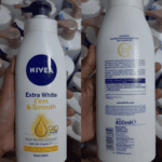 Front and back view of Nivea Extra White Firm & Smooth Body Lotion 400ml bottle showing Q10 and Vitamin C formula details, ingredient list, and product description for firmer, smoother, radiant skin.