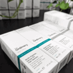 Multiple boxes of The Ordinary Multi-Peptide Serum for Hair Density displayed on a counter. The minimalist white and teal packaging highlights the serum’s purpose for thicker, fuller, and healthier-looking hair for all hair types.