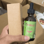 Mielle Rosemary Mint scalp and hair oil bottle displayed next to its cardboard packaging box.