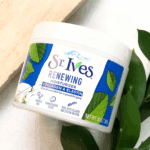 St. Ives Renewing Moisturizer Collagen & Elastin jar placed on a light surface with green leaves for a natural skincare look.