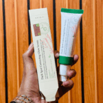 Hand holding AXIS-Y Dark Spot Correcting Glow Serum tube and box