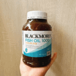 Hand holding Blackmores Fish Oil 1000 odourless omega-3 supplement bottleHand holding Blackmores Fish Oil 1000 odourless omega-3 supplement bottle