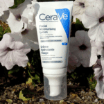 CeraVe PM facial moisturising lotion tube placed outdoors among white flowers