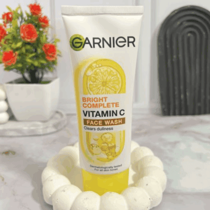 Garnier Bright Complete Vitamin C face wash placed on surface with decorative background