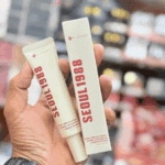 Hand holding K-Secret Seoul 1988 retinal liposome eye cream and retail box packaging