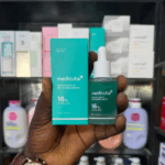 Hand holding Medicube Azelaic Acid 16 BB Calming Serum bottle and box in retail store
