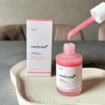 Medicube PDRN Pink Peptide Serum open bottle with dropper and packaging on tray