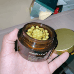 Medicube Deep Vita C Capsule Cream opened in hand showing encapsulated vitamin C beads