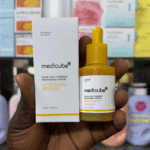 Hand holding Medicube Kojic Acid Turmeric Niacinamide Serum bottle and box inside a skincare store