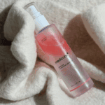 Medicube PDRN Pink Glutathione Serum Mist showing pink serum texture on soft fabric background