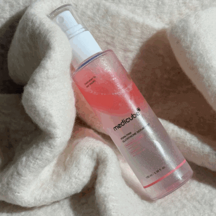 Medicube PDRN Pink Glutathione Serum Mist showing pink serum texture on soft fabric background