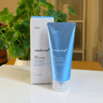 Medicube Zero Foam Cleanser displayed with original box on a table next to green indoor plant
