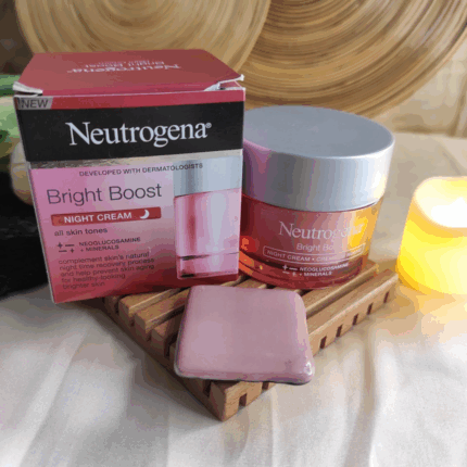 Neutrogena Bright Boost Night Cream jar displayed beside original box on wooden tray with candle and skincare setup