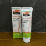 Palmer’s Cocoa Butter Formula stretch marks massage cream tube placed in front of box on tabletop display