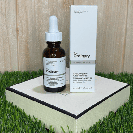 The Ordinary Moroccan Argan Oil bottle displayed with original box packaging on a decorative platform