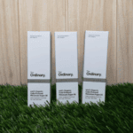 Three boxes of The Ordinary 100% Organic Cold-Pressed Moroccan Argan Oil displayed on grass surface