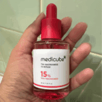 Medicube TXA Niacinamide 15 Serum bottle held in hand showing label and dropper