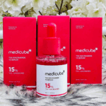 Medicube TXA Niacinamide 15 Serum bottle with multiple product boxes background