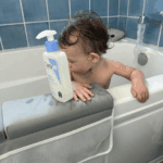 Baby in bathtub with CeraVe Baby Moisturizing Lotion 473ml pump bottle, gentle fragrance free baby lotion developed with pediatric dermatologists available in Sri Lanka