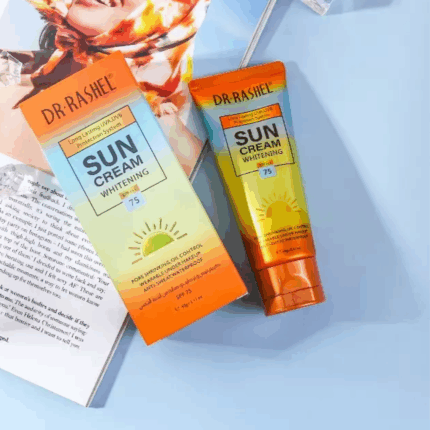 Flat lay of Dr. Rashel Sun Cream Whitening SPF 75 tube and box placed on an open magazine with decorative ice cubes on a light blue background.