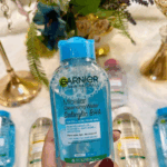 Garnier Micellar Cleansing Water Salicylic BHA 125ml bottle held in hand with multiple skincare bottles background acne care makeup remover Sri Lanka