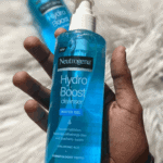 Close up hand holding Neutrogena Hydro Boost Water Gel Cleanser 200ml pump bottle on soft fabric background hydrating hyaluronic acid facial cleanser Sri Lanka