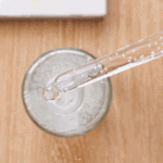 Close up of SKIN1004 Madagascar Centella Tone Brightening Capsule Ampoule dropper above bottle showing capsule texture