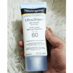 Hand holding Neutrogena Ultra Sheer Dry-Touch Sunscreen SPF 60 88ml showing front label