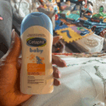 “Hand holding Cetaphil Baby moisturizing bath and wash bottle with blue cap, gentle cleanser for baby skin in indoor setting”